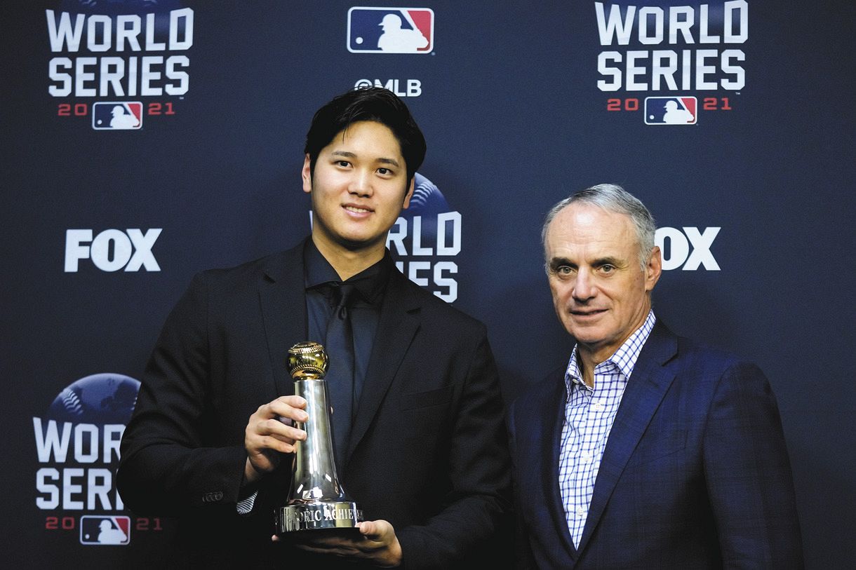 「MLBヒストリック・アチーブメント賞」のトロフィーを手にする大谷翔平（左）、右はマンフレッド・コミッショナー＝AP
