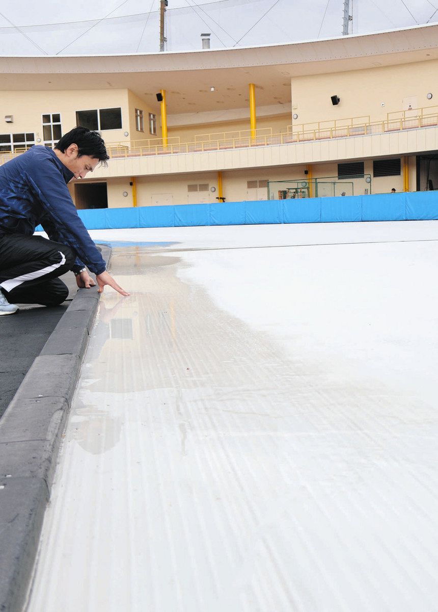 氷の表面が溶けてできた水たまりを確認する職員＝恵那市武並町の県クリスタルパーク恵那スケート場で
