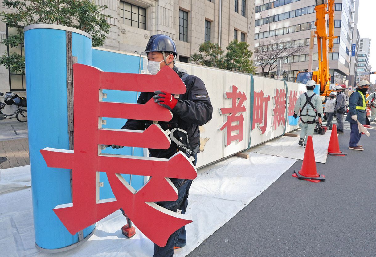 撤去作業が始まった「長者町繊維街」のアーチ看板＝11日午前、名古屋市中区長者町通で