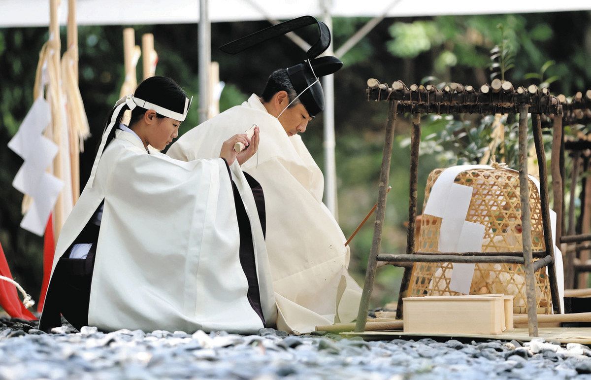 御船代祭で鎌を掲げる物忌役の工藤さん（左）＝伊勢市の伊勢神宮外宮で