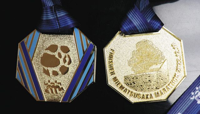 松阪市の特産品がデザインされたメダルの表面（左）と裏面＝松阪市役所で