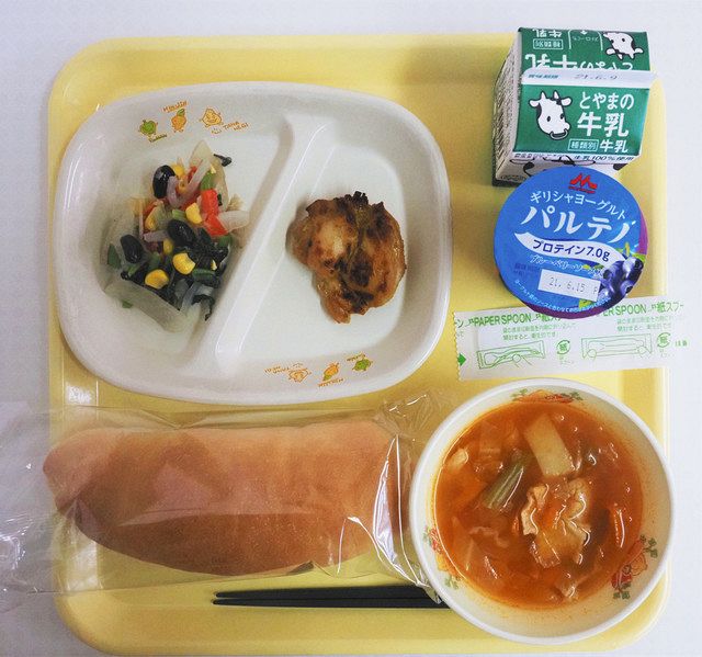 聖火リレーを応援する黒部市の特別給食。左上の皿に「五輪カラーサラダ」（左）と「チキンティッカ」。右下が「聖火リレースープ」＝黒部市石田小で 