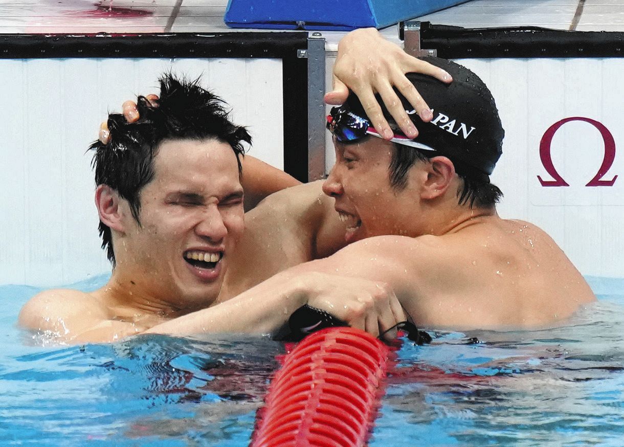 男子100メートルバタフライ決勝でレースを終え、抱き合って喜ぶ金メダルの木村敬一（左）と銀メダルの富田宇宙