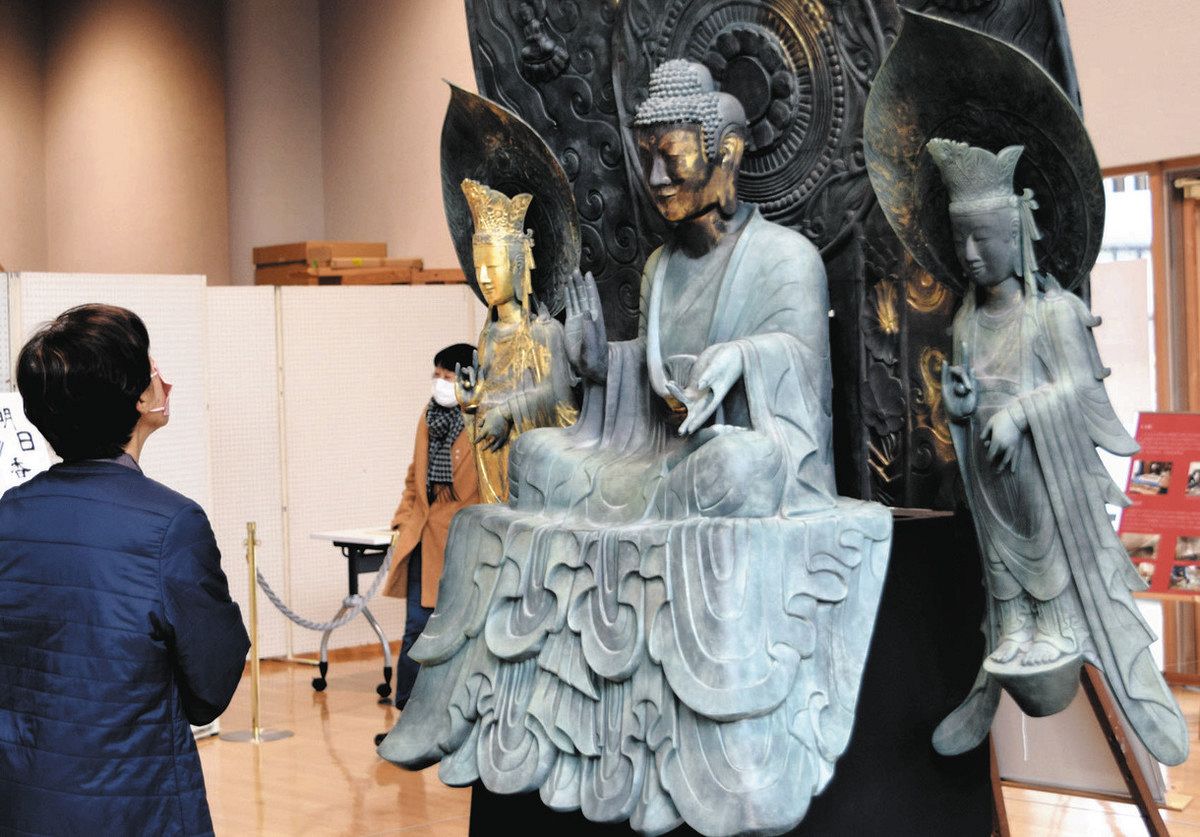 精巧に複製された釈迦三尊像を間近で眺める来場者＝飛騨市古川町の市文化交流センターで