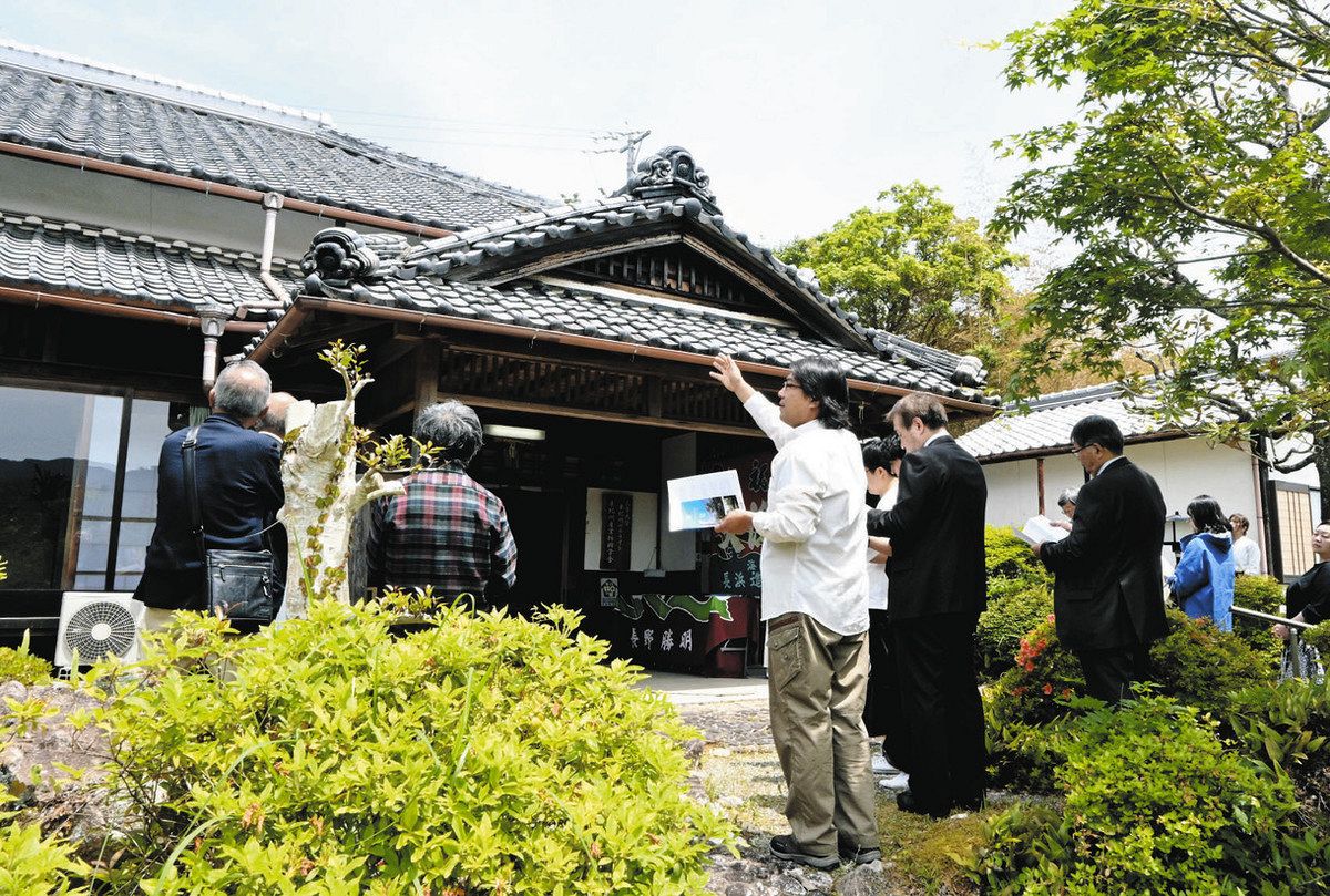 建物の特徴を説明する疇地さん（中）＝尾鷲市天満浦の天満荘で