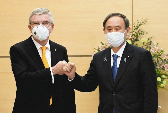 会談を前にグータッチを交わす菅首相とＩＯＣのトーマス・バッハ会長（左）
