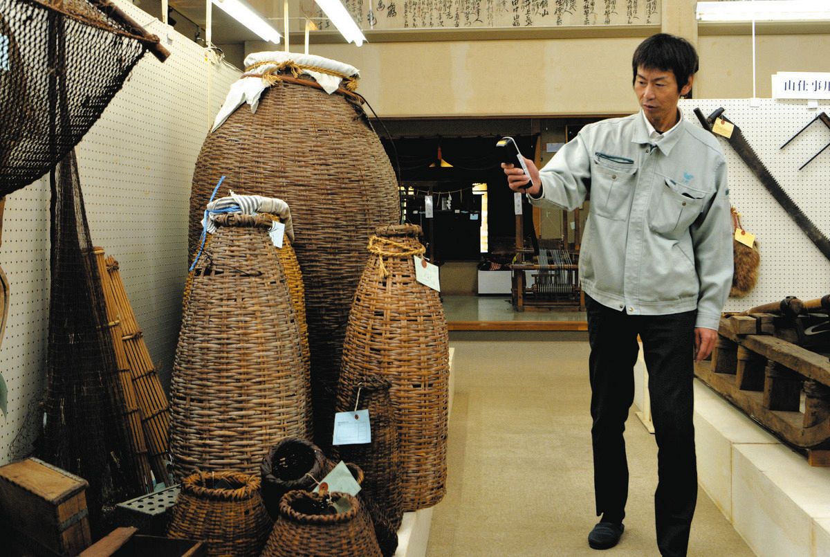 ICチップの読み取り機器を手に館内を巡回する三好館長＝飛騨市宮川町の飛騨みやがわ考古民俗館で