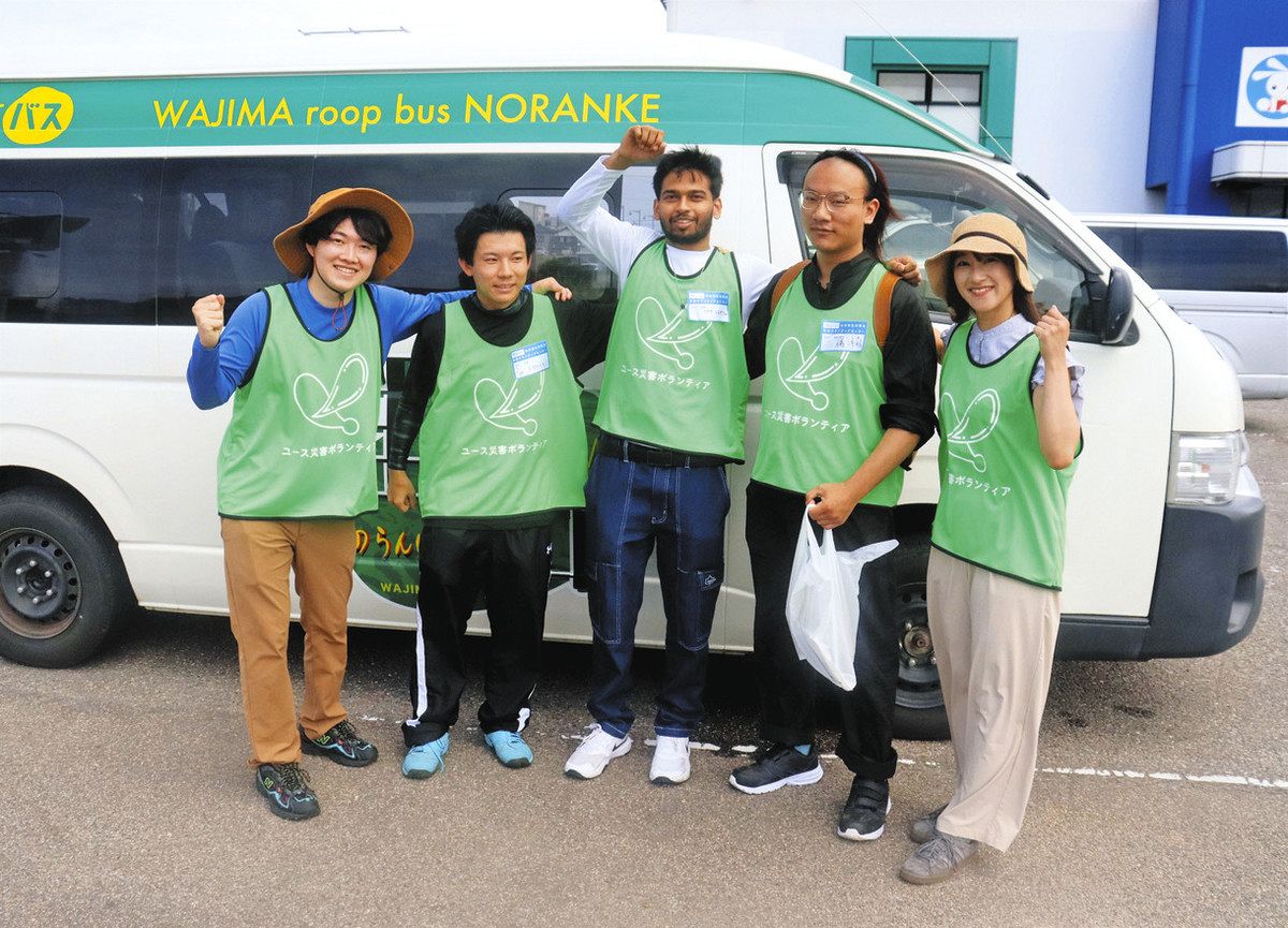 第１陣で派遣された学生らと、バスなどを手配した法人理事長の上田啓瑚さん（左端）＝石川県輪島市で
