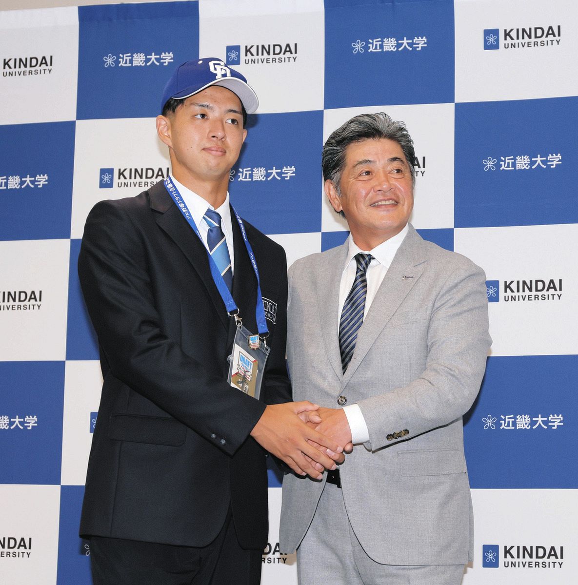 工藤新監督（右）からドラフト指名のあいさつを受けた近大の宮原廉
