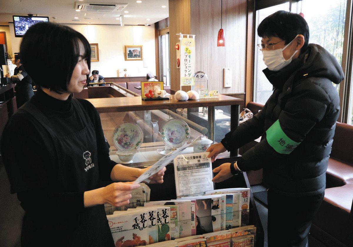防犯啓発の新聞を設置する署員＝多治見市音羽町のCafeさいわいジョイフル店で
