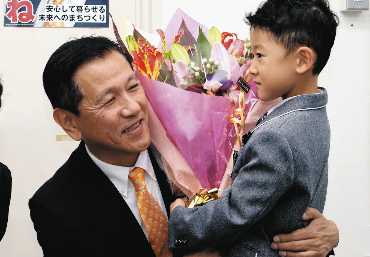 3選を決めて笑顔で花束を受け取る小坂さん（左）＝恵那市長島町で
