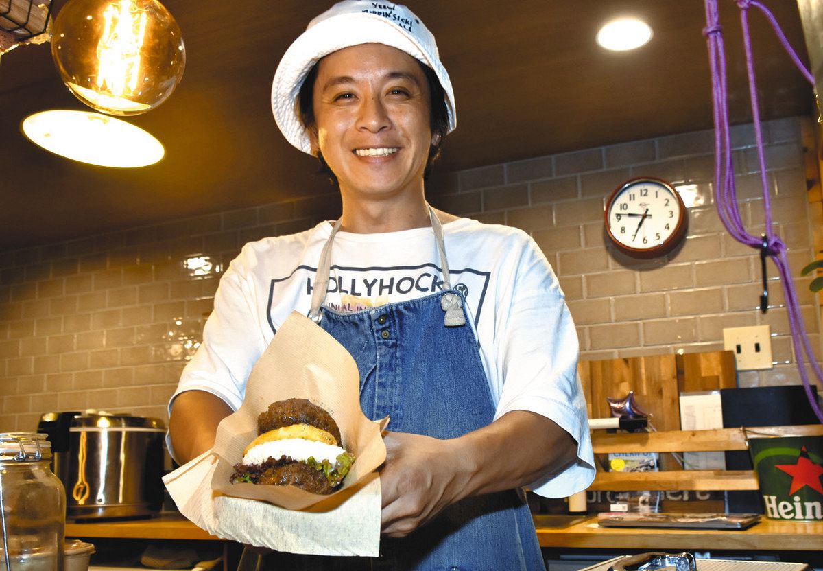 ダブルバーグを手に笑顔を見せる加藤さん＝津市一身田上津部田で