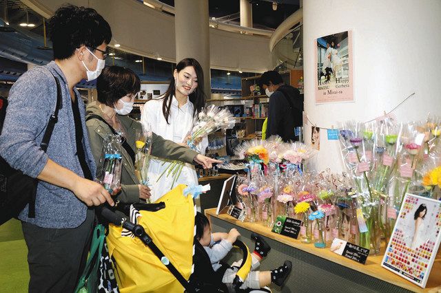 ガーベラのアレンジを担当した天玲美音さん（左から３人目）と来場客＝浜松市中区の浜松科学館で 