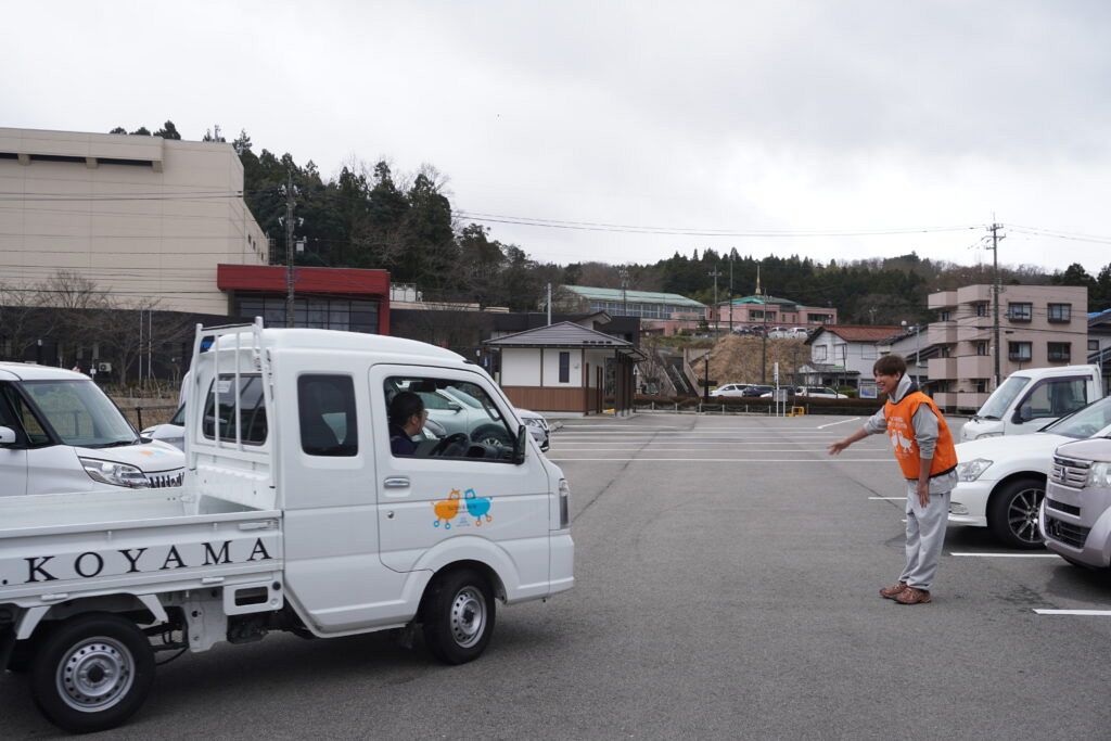 現地で車を見送るＮＥＷＳ小山慶一郎(同協会のHPより)