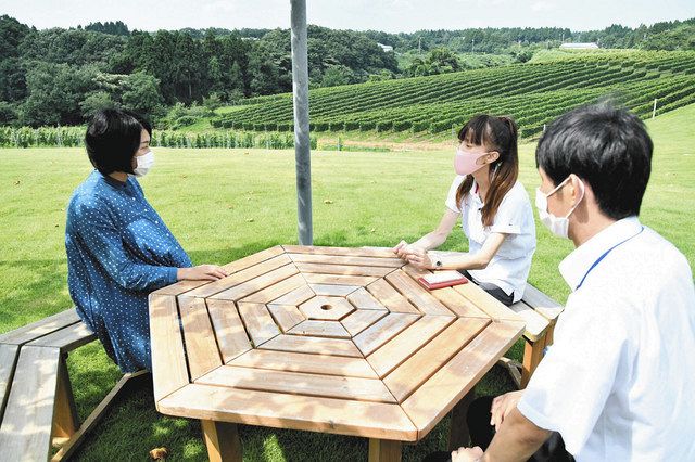 現役協力隊員の２人から説明を受ける小森美紗さん（左）＝穴水町旭ケ丘の能登ワインで
