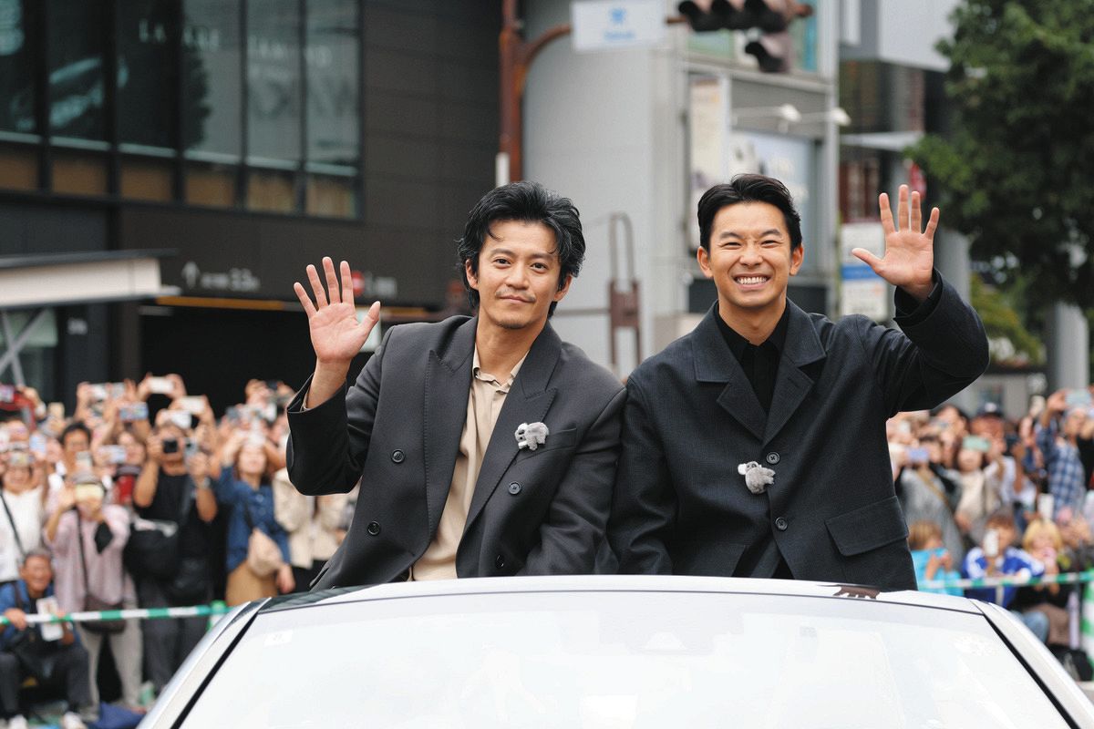 オープンカーに乗り込み、沿道の人たちに手を振る俳優の小栗旬さん（左）、仲野太賀さん