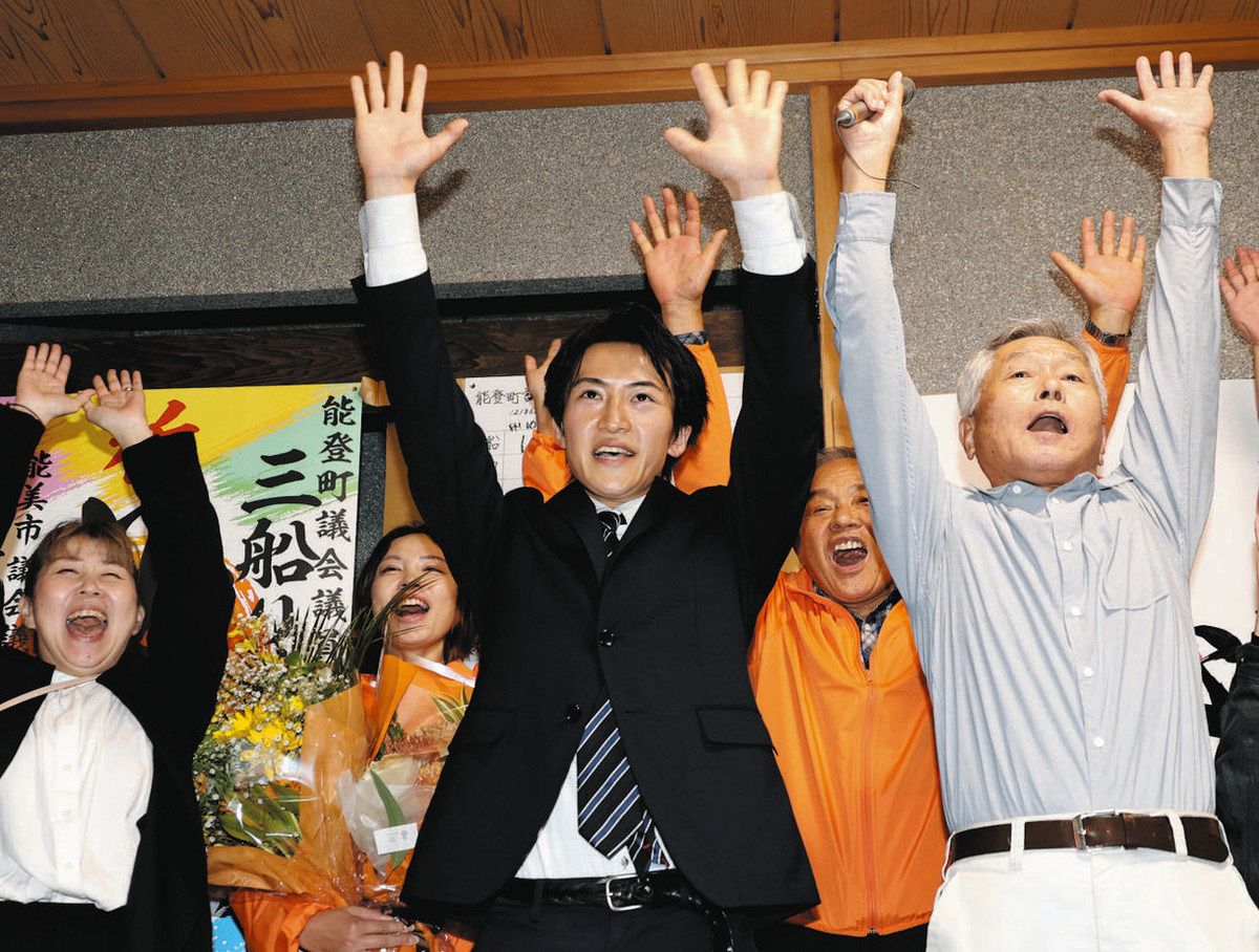 当選を確実にし、支援者と一緒に万歳をする三船涼圭さん（中）＝25日、石川県能登町恋路で