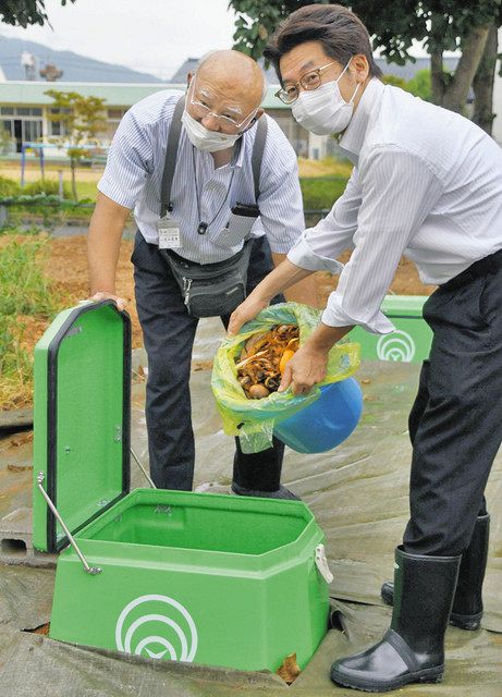 生ごみ分解処理容器に生ごみを投入する佐々木市長（右）＝鯖江市吉川小で 