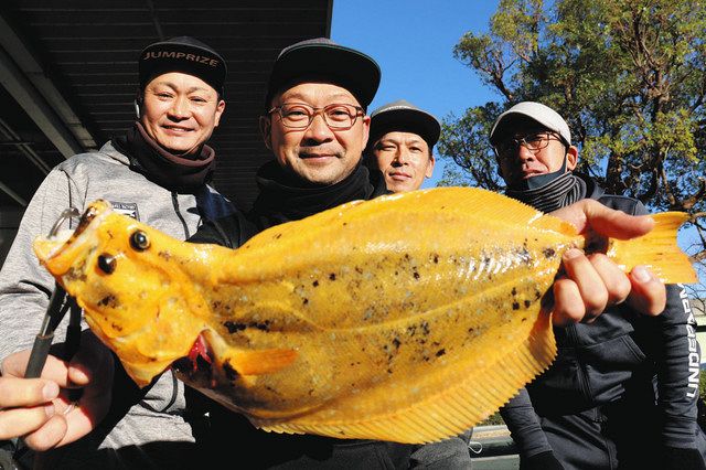 永井秀和さん（左から２人目）が釣り上げた「黄金色のヒラメ」＝浜松市東区で
