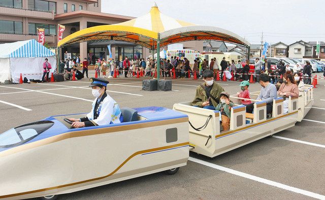 ミニ北陸新幹線に乗って笑顔を見せる親子ら＝あわら市の市中央公民館で