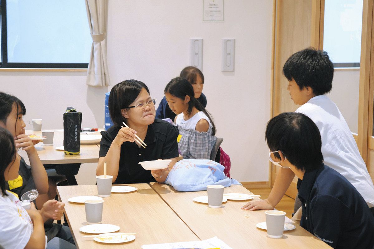 英語を使って「寿司ピザ」の感想を言い合うALTと小中学生＝喬木村のPERCHで