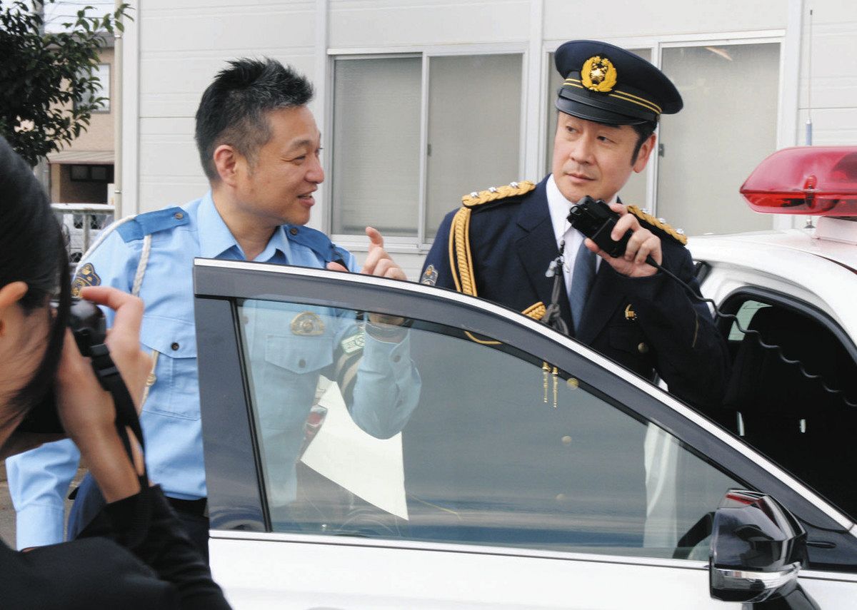 ポスター用の撮影で、署員からポーズのアドバイスを受ける市川さん（右）＝岐阜羽島署で
