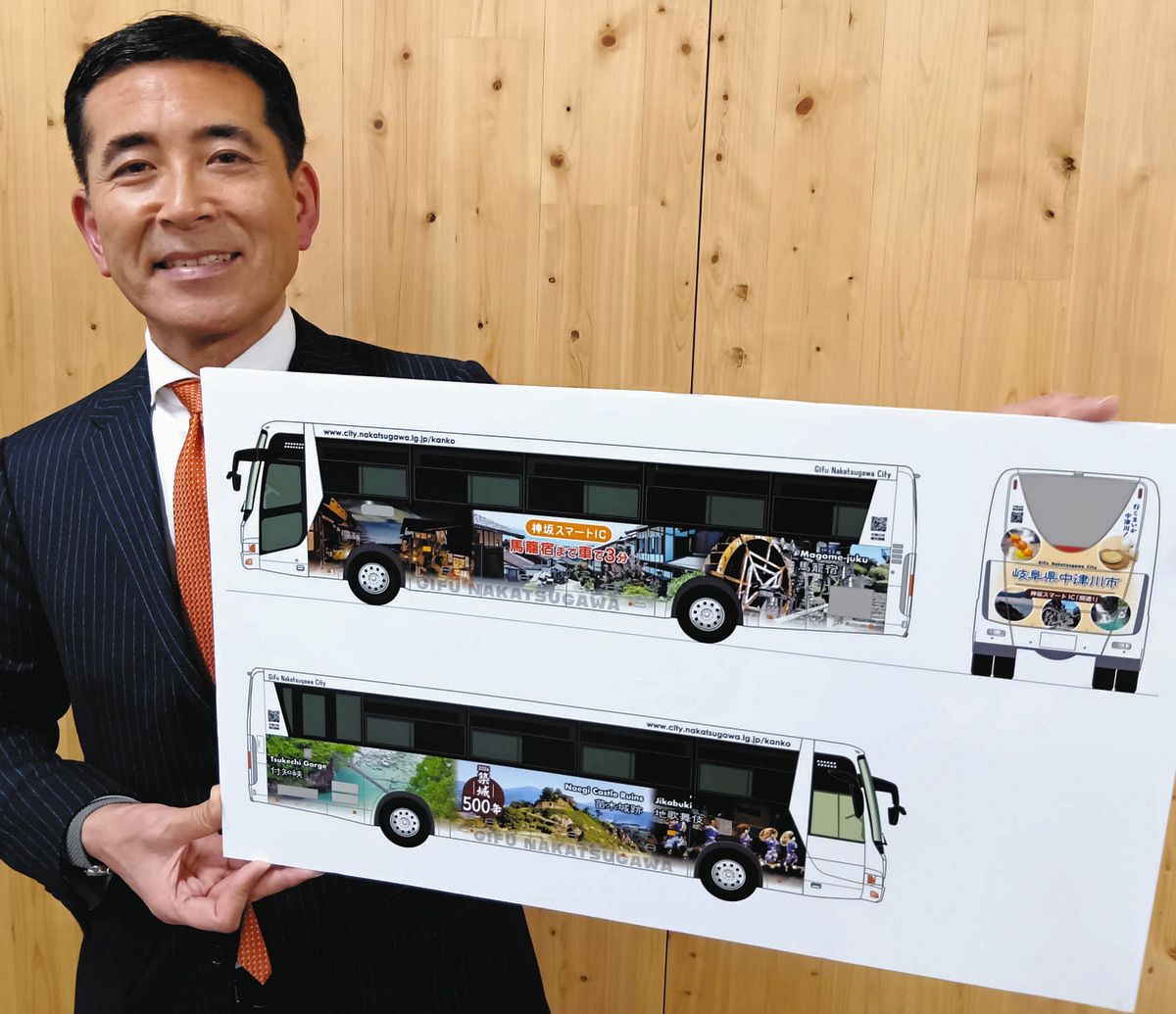 ラッピングバスをPRする小栗市長＝中津川市役所で