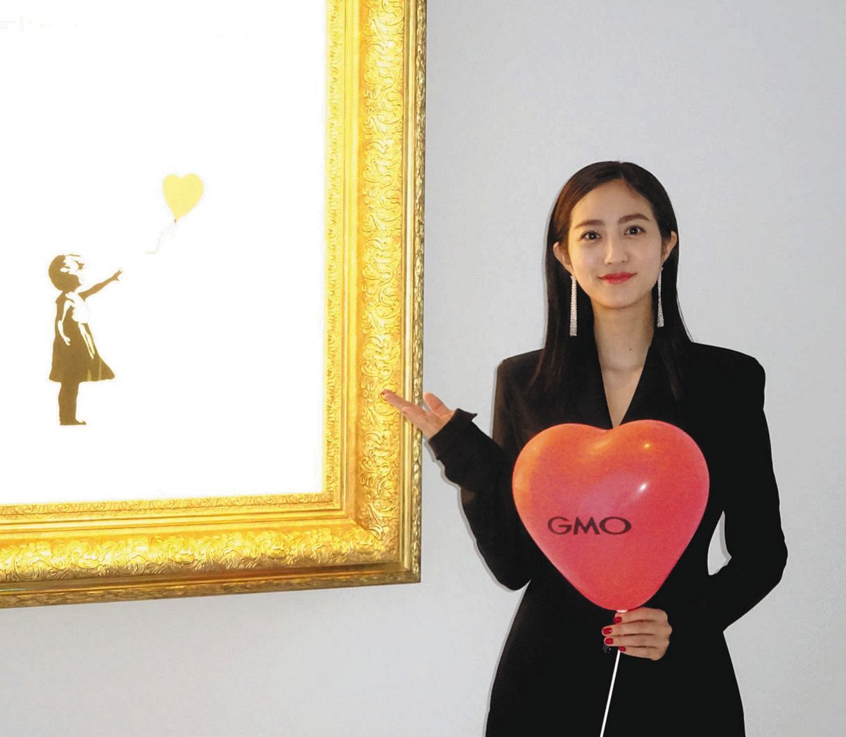 ５日にオープンするアートスペース「世界一小さな美術館＠ＧＭＯデジタル・ハチ公」の第１弾展示でバンクシーの代表作「風船と少女」を横に笑顔の堀田茜