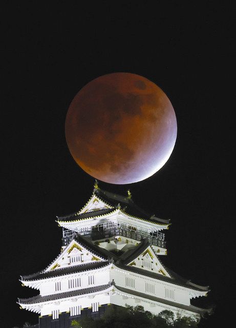 赤い月、城と映える夕暮れ　部分月食