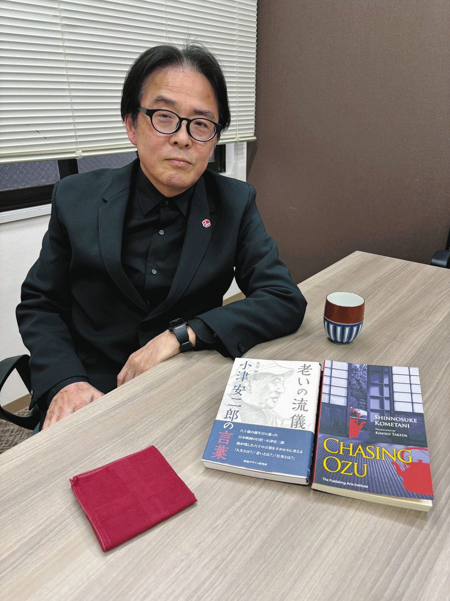 著者の米谷さんと米国で英訳された『CHASING OZU（小津を追いかけて）』（手前（右））。赤いハンカチは遺族から譲り受けた小津の遺品だという＝東京都新宿区の双葉社で