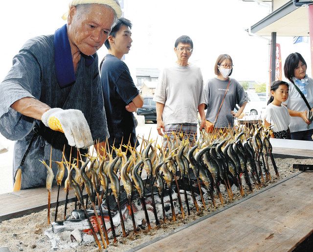 アユの塩焼きを丁寧に焼く野原四郎さん（左）＝砺波市庄川町示野の道の駅庄川で 