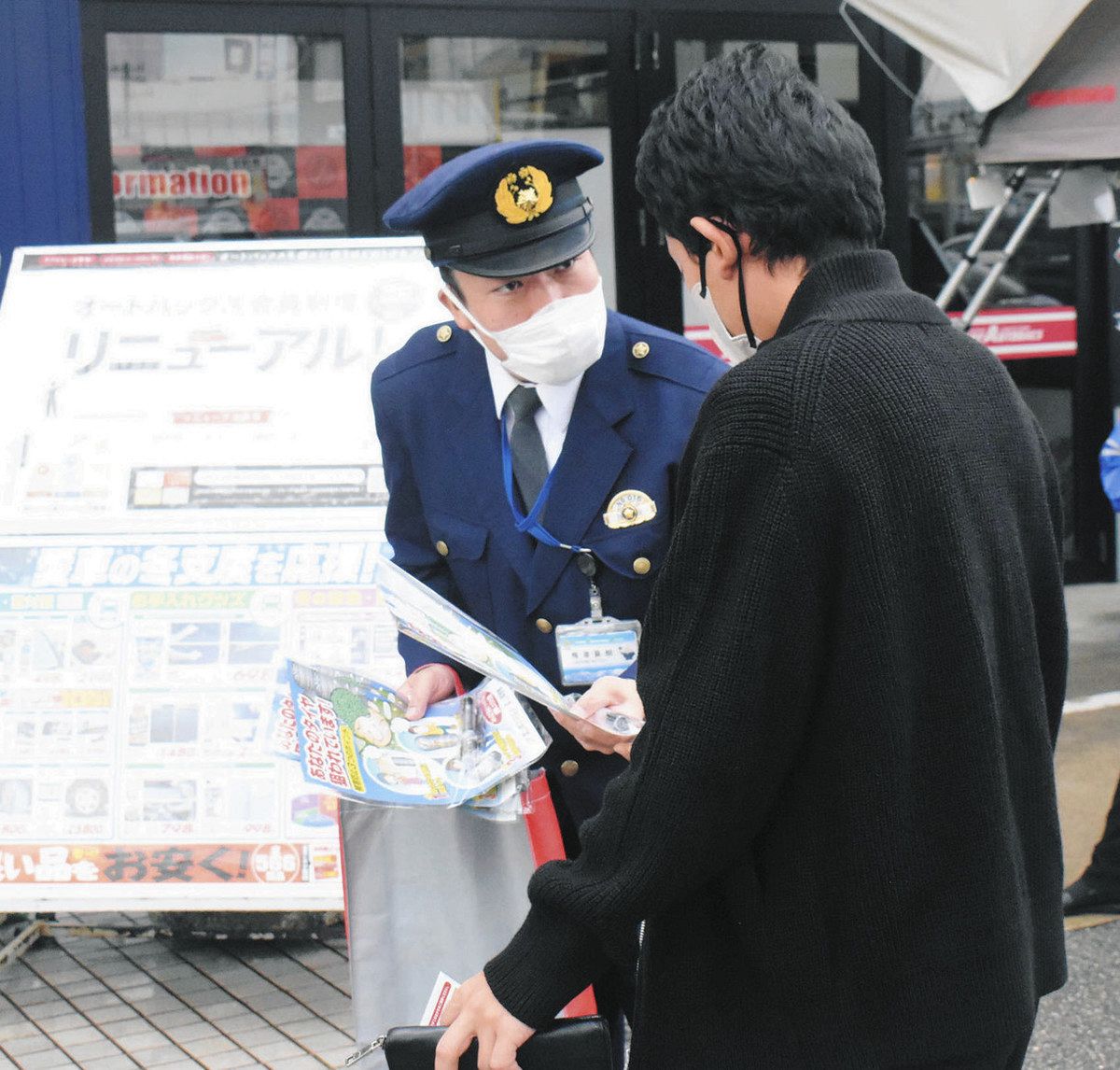 利用客にタイヤの盗難への注意を呼びかける署員（左）＝富山市婦中町塚原のスーパーオートバックス富山南で 