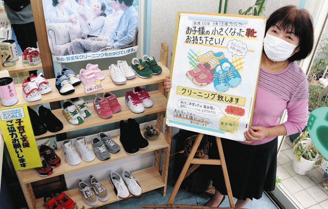 靴の回収を呼び掛ける明子さんと、クリーニングをして並べられた子ども用の靴＝松阪市鎌田町のデアドラＳＡＮＣＯで