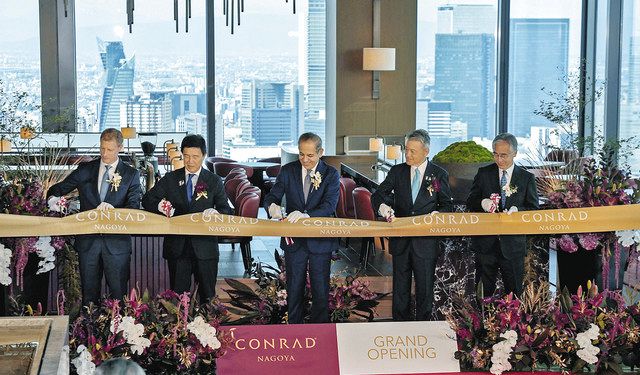 コンラット名古屋が開業しテープカットするマーカス・コッシュ総支配人（左）ら（後ろは名駅のビル群）＝名古屋・栄で