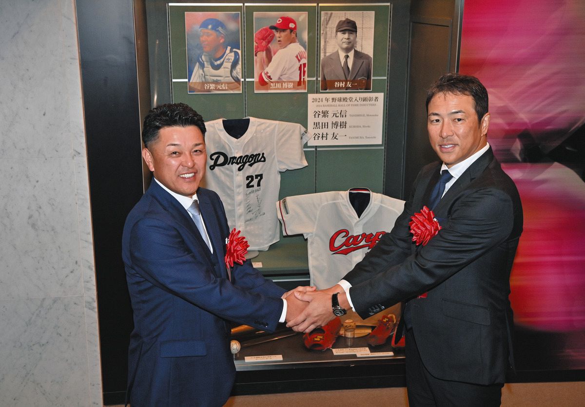 野球殿堂入り記念展示の前で握手する谷繁元信さんと黒田博樹さん