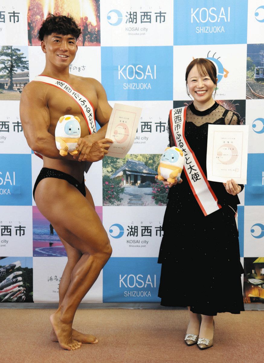 ふるさと大使の委嘱を受けて、笑みを浮かべる一之森さん（右）と自慢の筋肉美を披露する小池さん＝湖西市役所で
