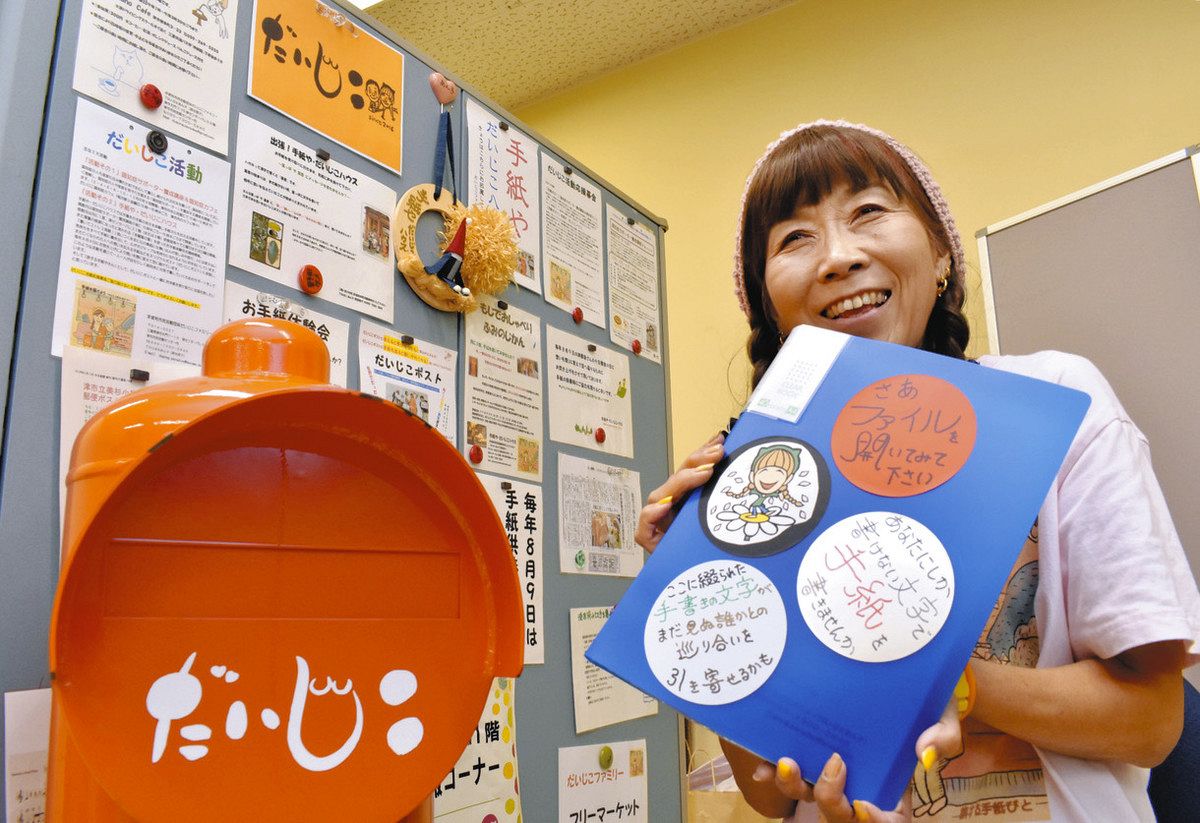 交換日記のノートが入ったファイルを持つ野田さん＝津市大門で