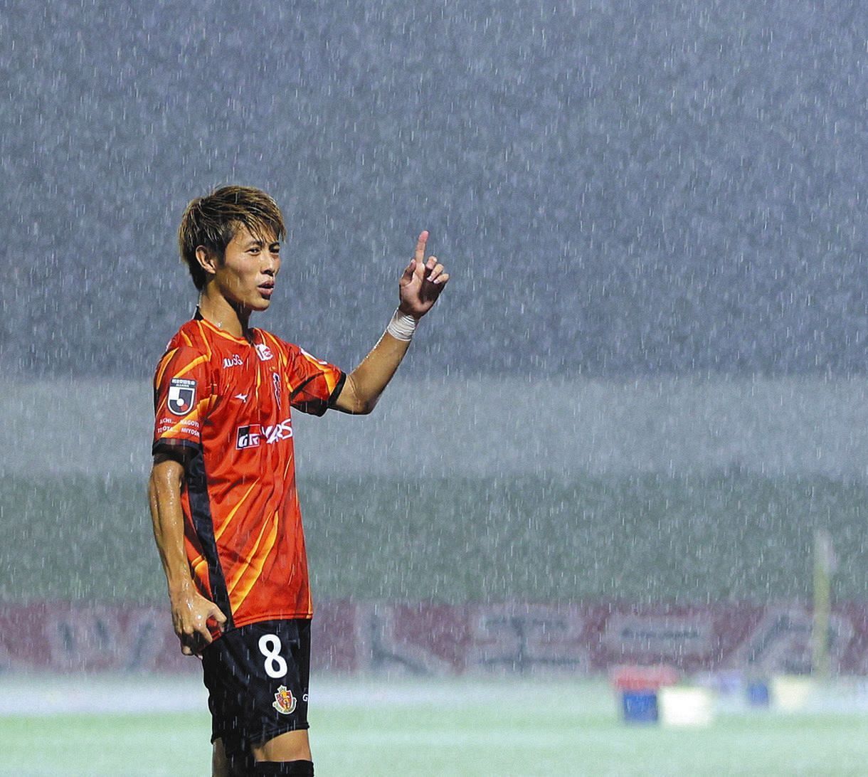 雷雨で試合が中断となり、稲妻が走る空を指さす名古屋・柿谷