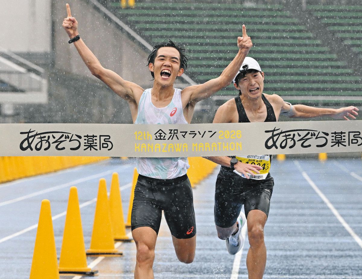 金沢マラソン総合男子で優勝した西川朋秀選手（左）と2位の山田祐生選手＝金沢市の西部緑地公園陸上競技場で
