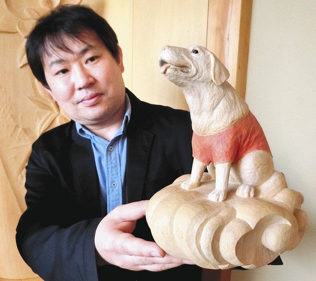 完成したペットの木像を手にする木村正和さん＝南砺市岩屋で 
