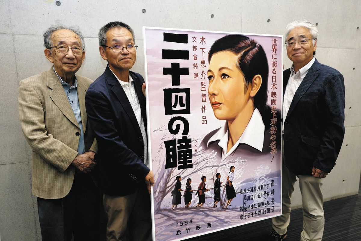 復刻された映画看板を手に来場を呼びかける実行委員たち＝津市鳥居町の中日新聞三重総局で

