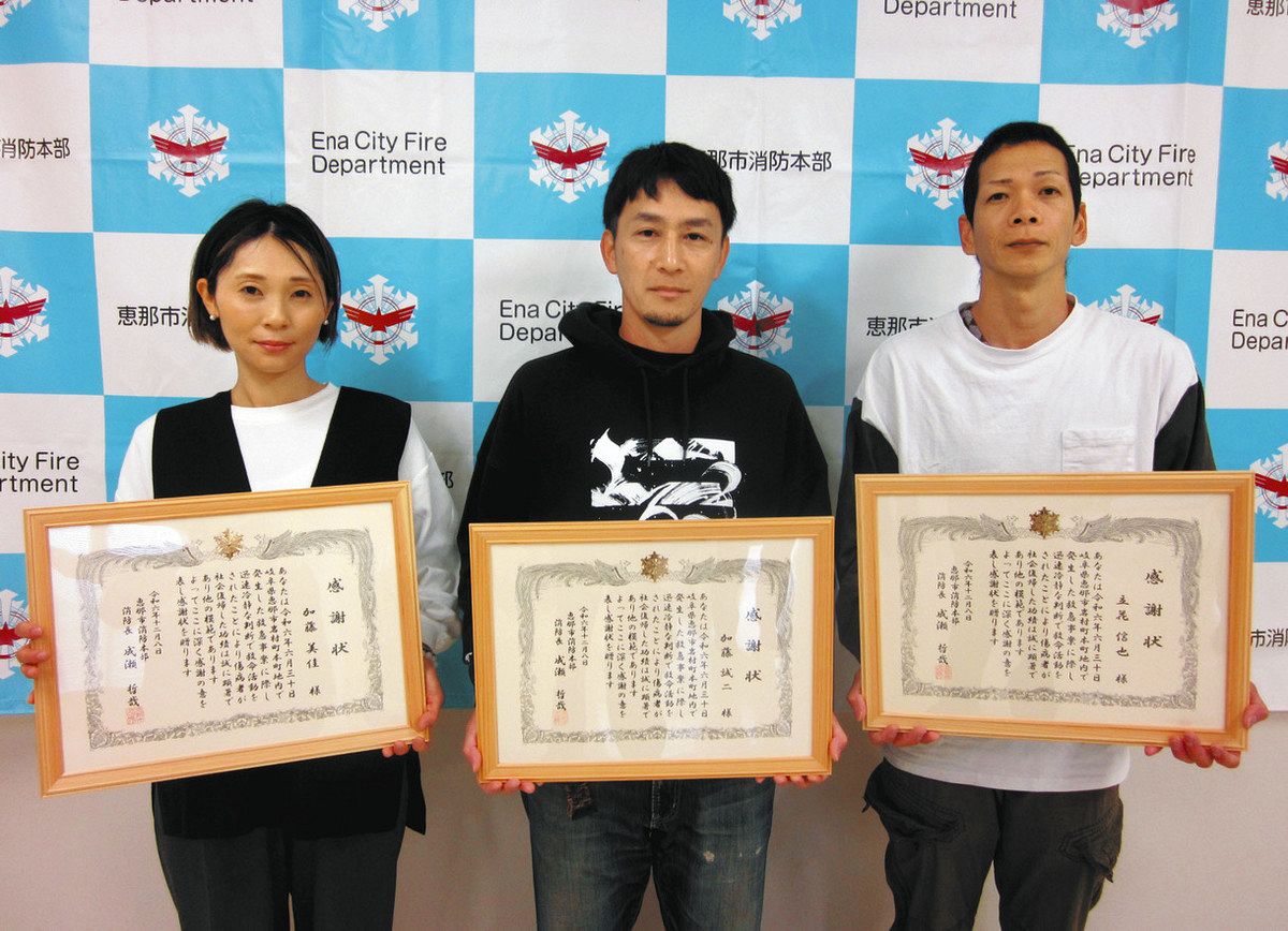 消防長表彰の感謝状を贈られた立花さん（右）と加藤さん夫妻＝恵那市長島町の市消防防災センターで