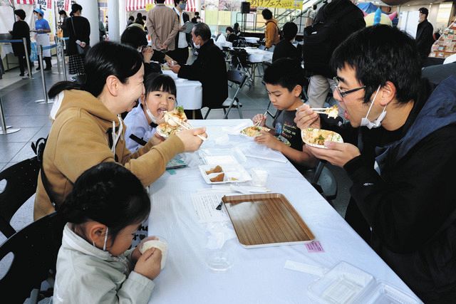 揚げたての厚揚げを味わう家族連れ＝福井市のハピテラスで