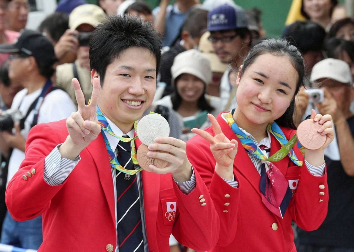 故郷・静岡県磐田市でリオ五輪のメダルを手にカメラに向かってＶサインをする水谷隼と伊藤美誠＝2016年12月21日 