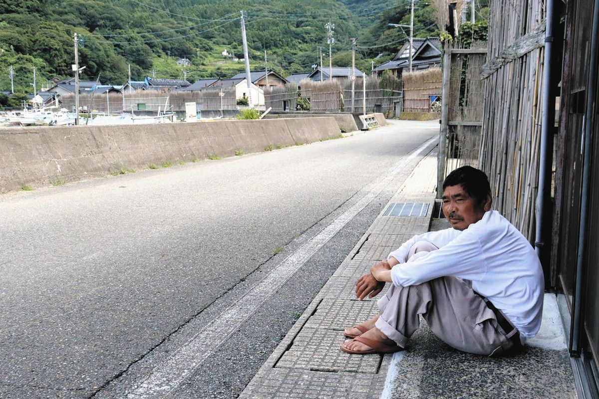 「海を見ていると落ち着く」と、漁港を眺めている橋下助松さん＝２６日、石川県輪島市大沢町で
