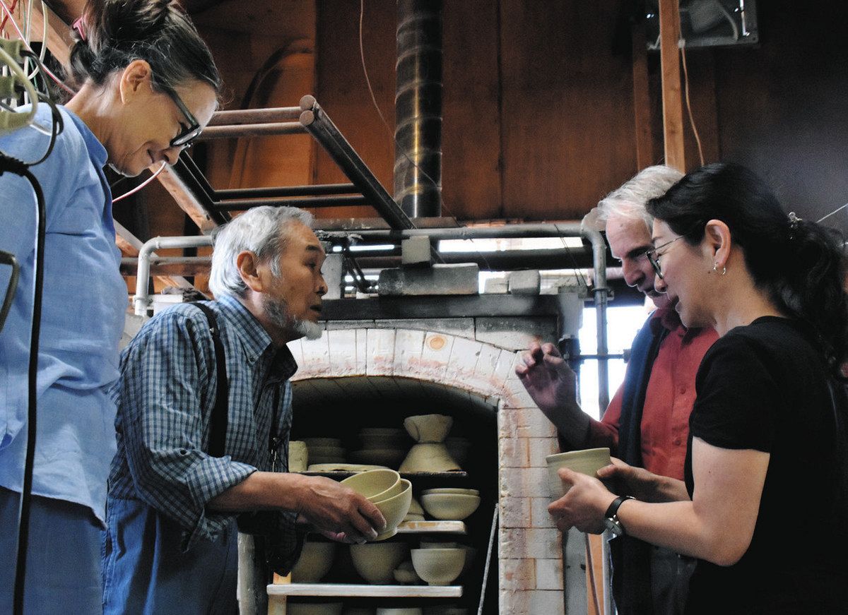 素焼きの工程を前に、作品を窯の中に並べる作業をする（左から）ベンテさん、柴田さんら＝多治見市滝呂町の滞在型作陶施設HO－CAで