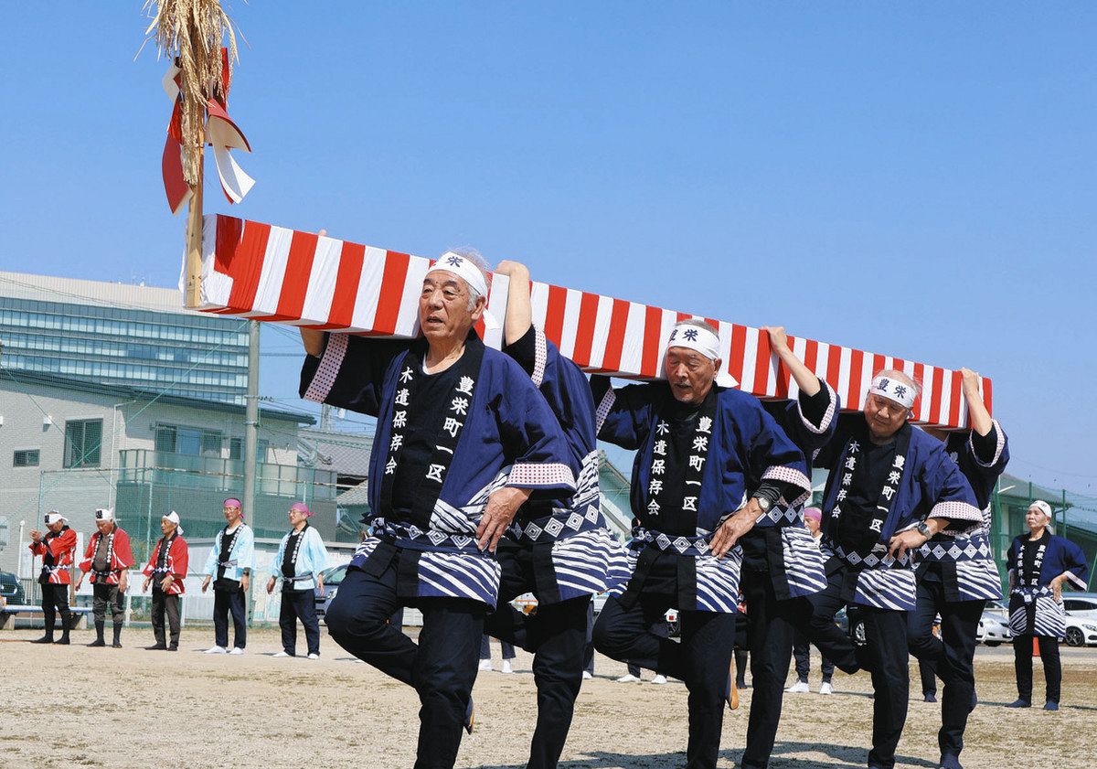 木遣り唄に合わせて棟木を担ぐメンバーら＝豊田市豊栄町で