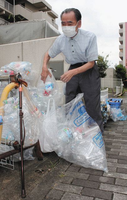 つえを置き、資源ごみを分別し直す玉井さん＝名古屋市北区で 