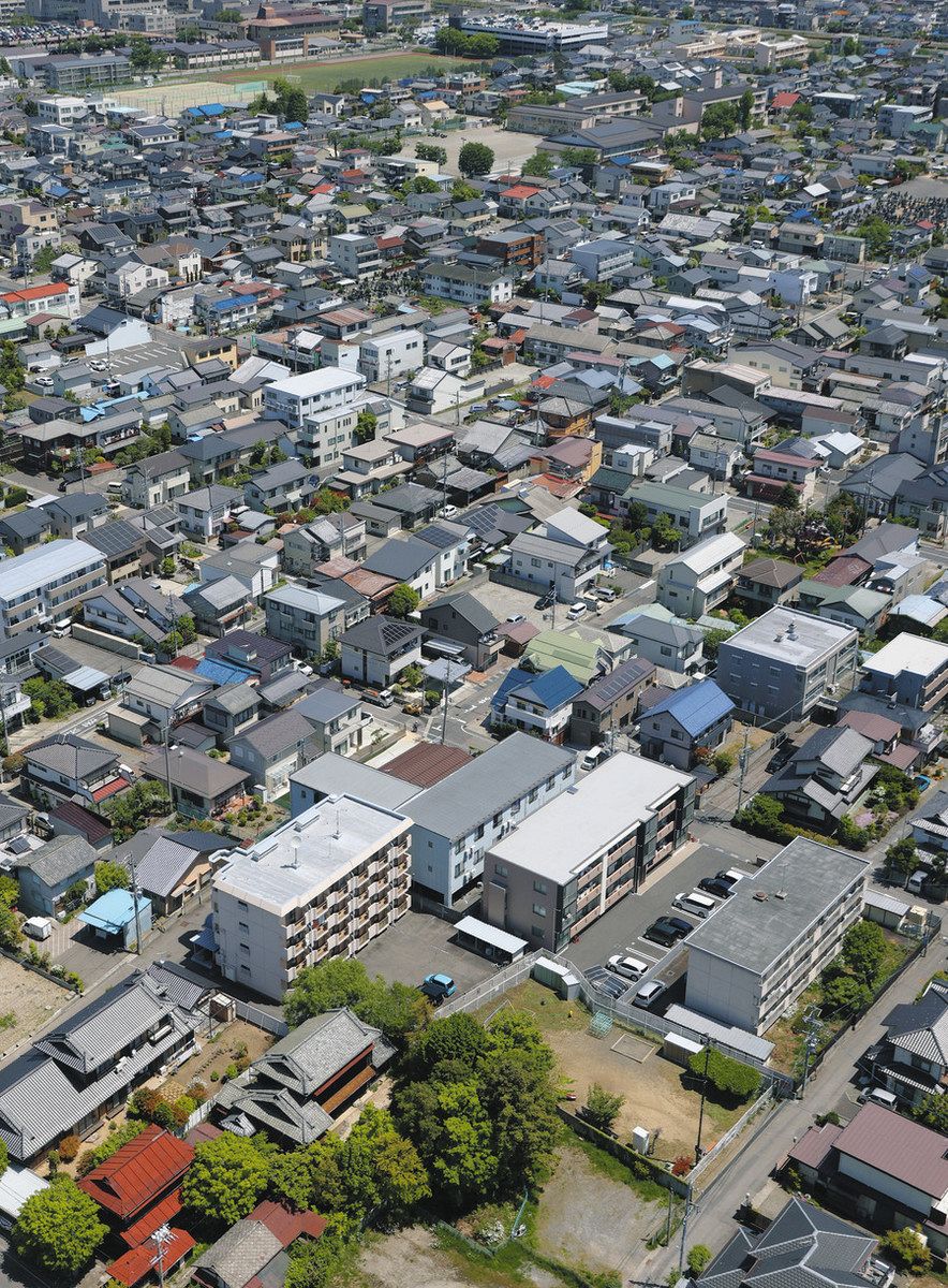 松本サリン事件の現場。手前の砂利の駐車場でサリンがまかれた＝長野県松本市で、本社ヘリ「まなづる」から（益田樹撮影）
