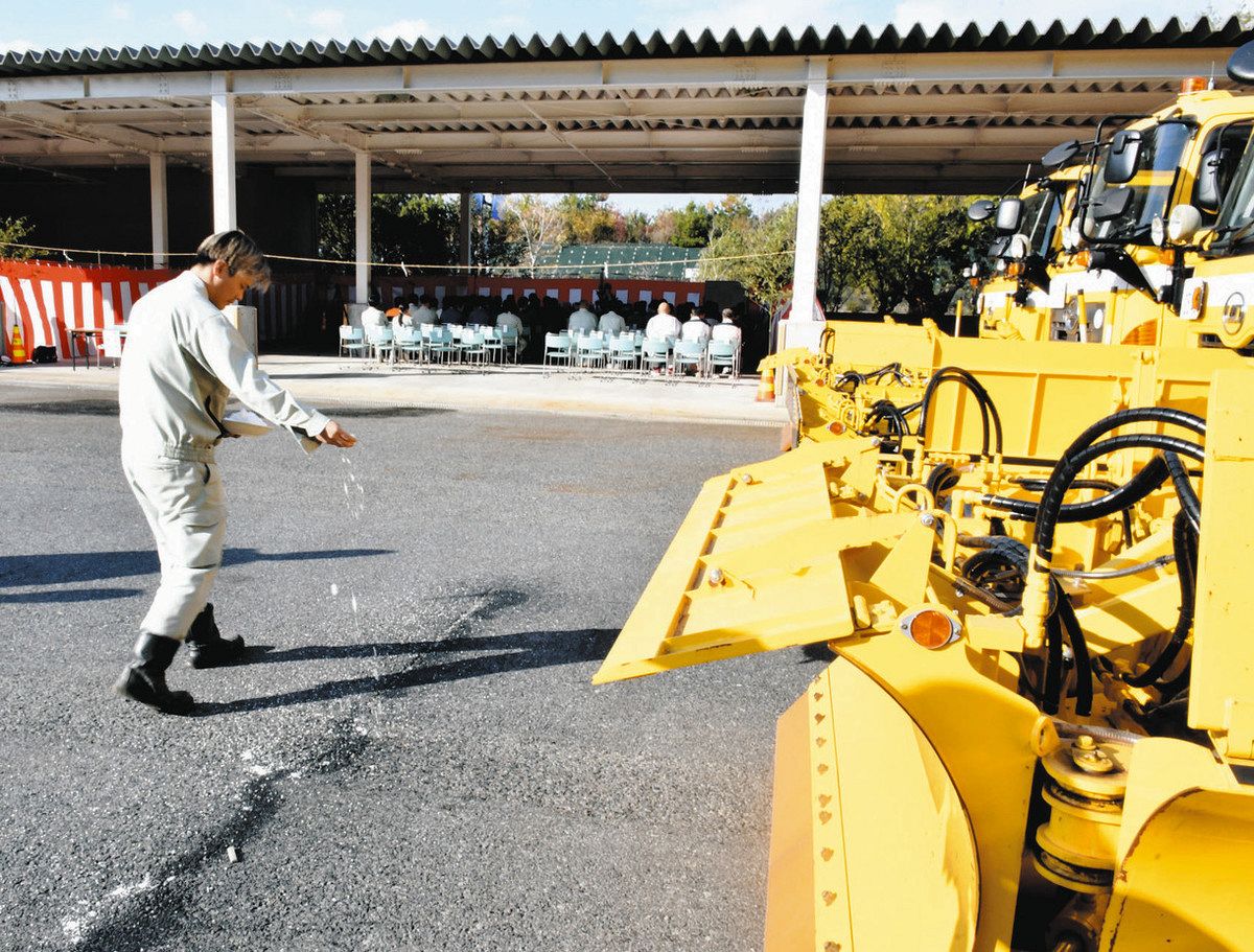車両の前に塩をまき清める関係者＝土岐市土岐津町の土岐南多治見ICで
